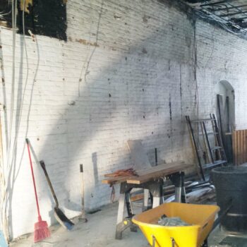 Interior of a worksite with a room, shovel, wheel barrel and a table saw